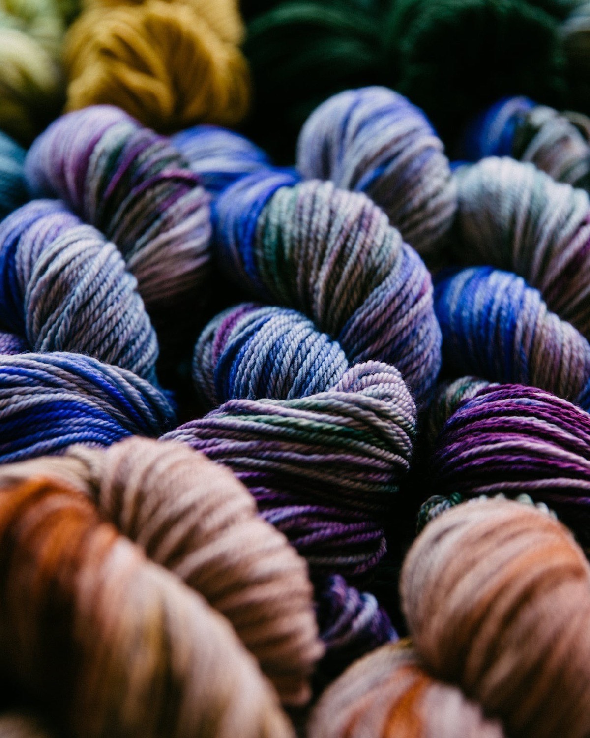Hand-dyed yarn skeins in blues, purples and rust